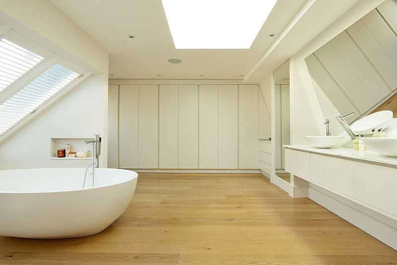 This is an example of a contemporary family bathroom in London with a vessel sink, flat-panel cabinets, a freestanding bath, an alcove shower and white walls.