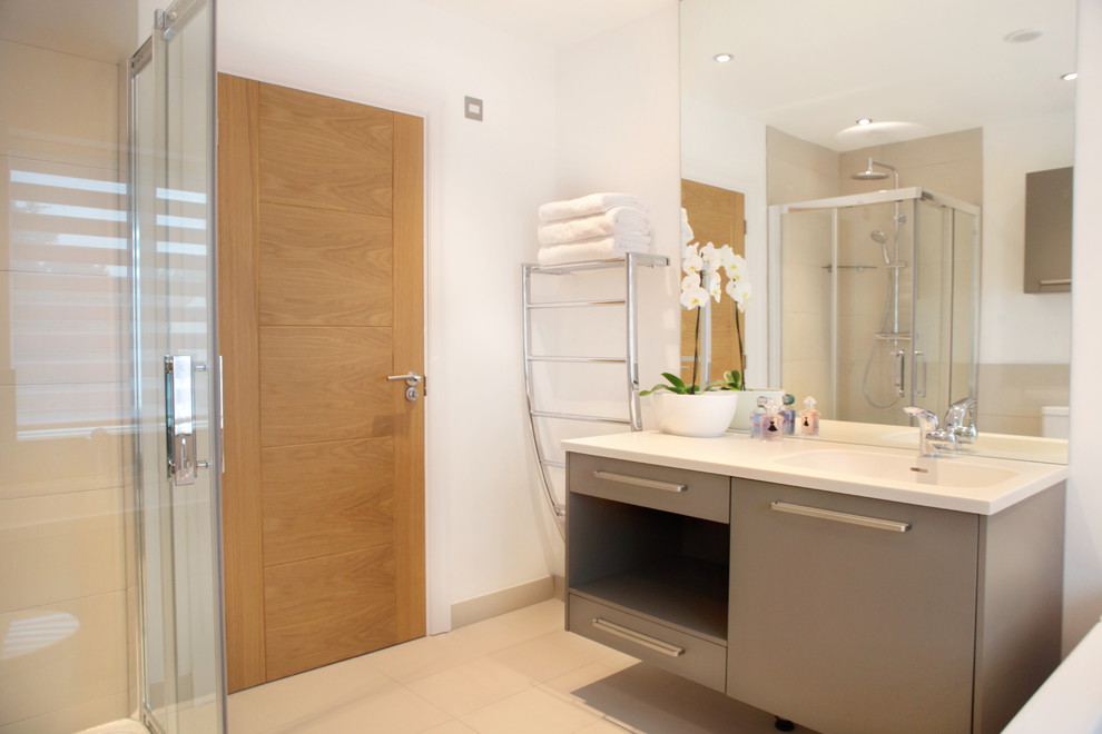 Cette image montre une salle de bain design de taille moyenne pour enfant avec un placard à porte plane, des portes de placard beiges, une douche d'angle, un mur blanc et un sol en carrelage de porcelaine.