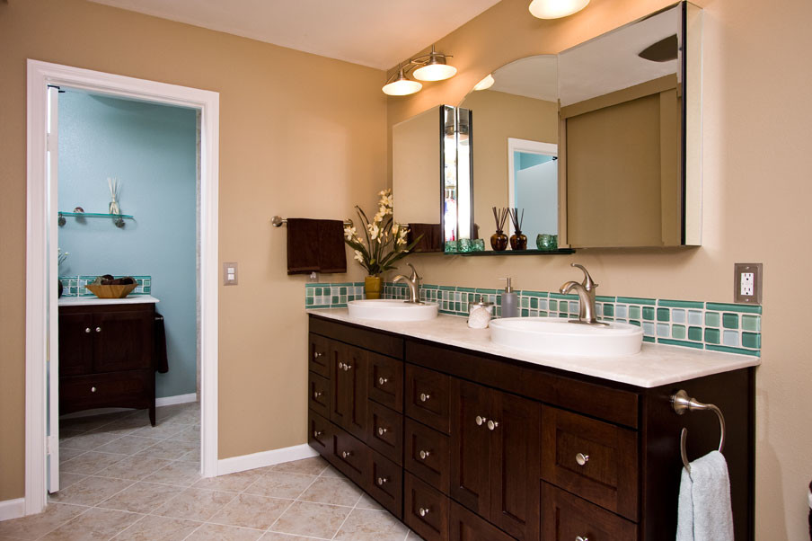 Immagine di una stanza da bagno contemporanea con lavabo a bacinella, ante in stile shaker, ante in legno bruno, piastrelle verdi, piastrelle di vetro e pareti beige
