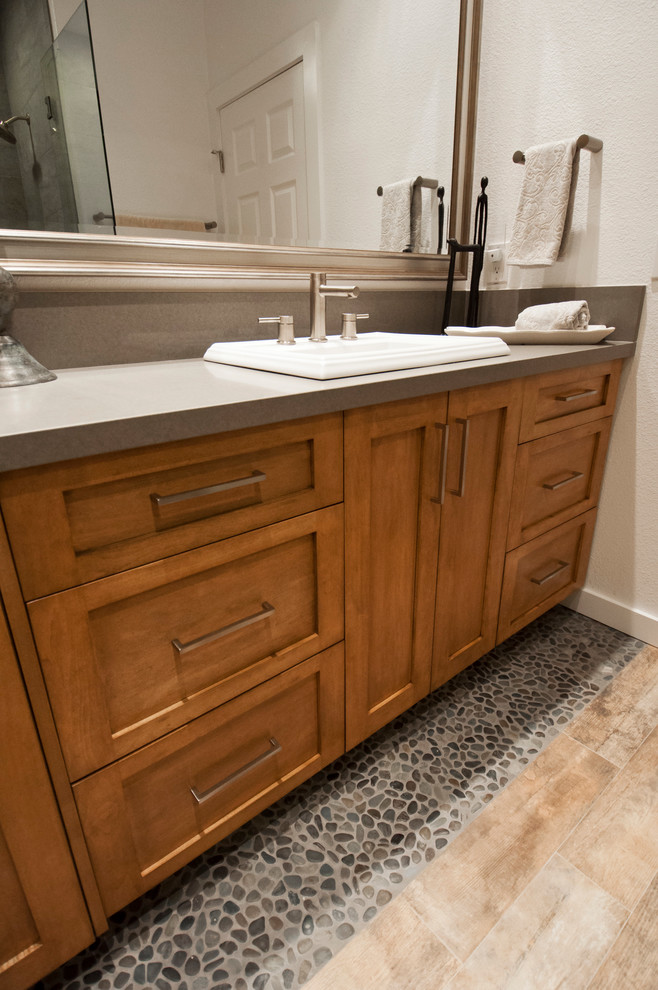 Cette photo montre une salle d'eau tendance en bois brun de taille moyenne avec un lavabo posé, un placard à porte shaker, un plan de toilette en quartz modifié, une douche d'angle, un carrelage gris et un carrelage de pierre.