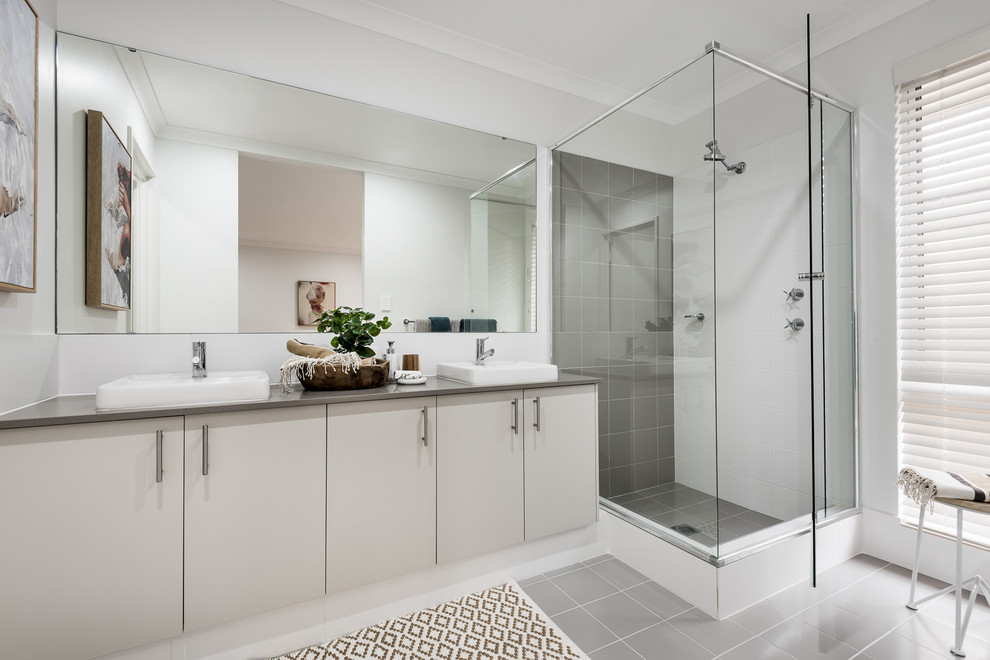 Inspiration for a medium sized contemporary shower room bathroom in Perth with flat-panel cabinets, beige cabinets, grey tiles, grey walls, grey floors, a hinged door, a corner shower, ceramic tiles, an integrated sink and engineered stone worktops.