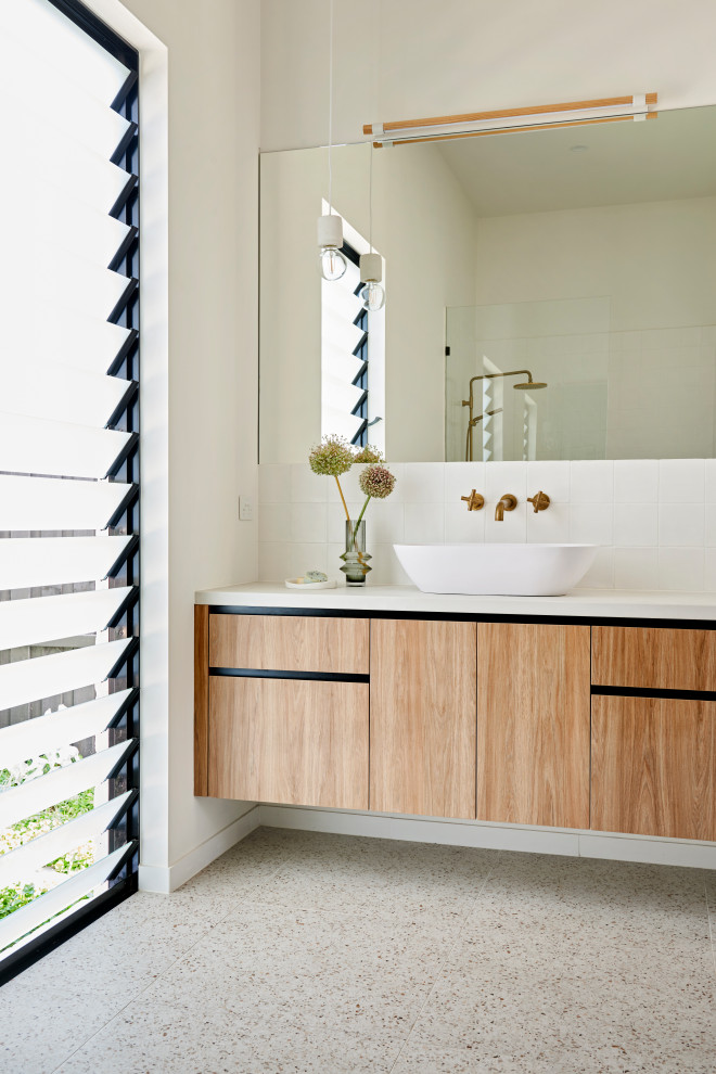 Großes Modernes Duschbad mit flächenbündigen Schrankfronten, hellbraunen Holzschränken, weißer Wandfarbe, Terrazzo-Boden, Aufsatzwaschbecken, grauem Boden, weißer Waschtischplatte, Einzelwaschbecken und schwebendem Waschtisch in Geelong