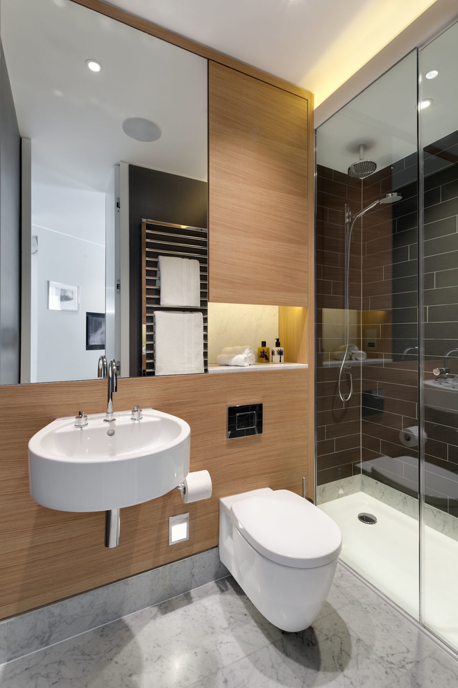 Inredning av ett modernt badrum, med ett väggmonterat handfat, en dusch i en alkov, en vägghängd toalettstol och svart kakel