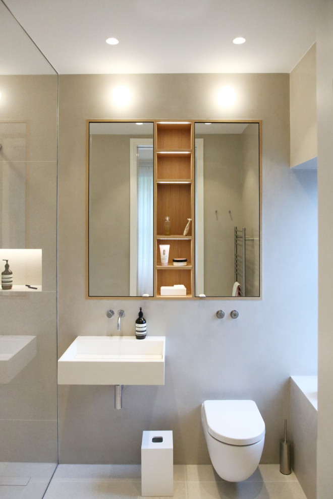 Idéer för ett litet modernt en-suite badrum, med en hörndusch, en vägghängd toalettstol, grå kakel, porslinskakel, klinkergolv i porslin, ett väggmonterat handfat och grått golv