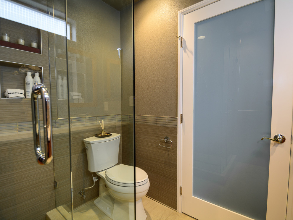 This is an example of a large world-inspired ensuite bathroom in Los Angeles with flat-panel cabinets, a corner shower, a two-piece toilet, beige tiles, porcelain tiles, grey walls, porcelain flooring and a submerged sink.