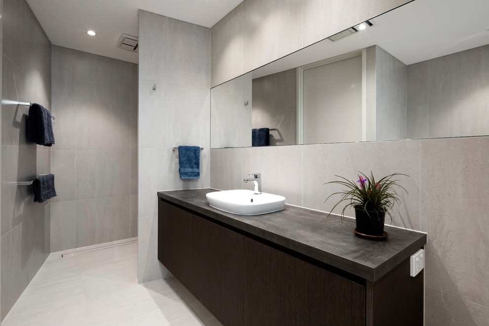 Стильный дизайн: ванная комната в современном стиле с плоскими фасадами, темными деревянными фасадами, открытым душем, серой плиткой, настольной раковиной, бежевым полом, открытым душем и серой столешницей - последний тренд