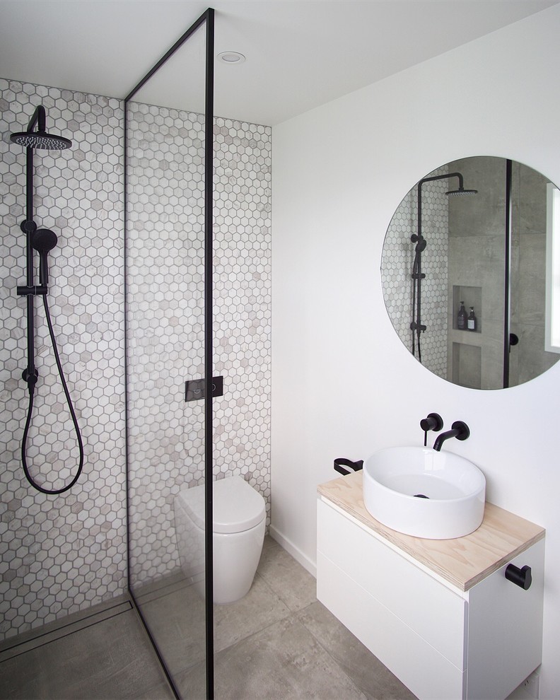 Inspiration för moderna beige badrum med dusch, med släta luckor, vita skåp, våtrum, en toalettstol med hel cisternkåpa, grå kakel, mosaik, grå väggar, betonggolv, ett fristående handfat, träbänkskiva, grått golv och med dusch som är öppen