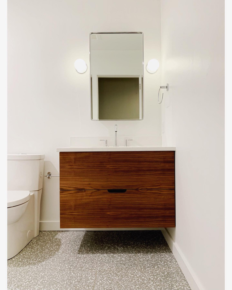 フィラデルフィアにある高級な小さなコンテンポラリースタイルのおしゃれな浴室 (フラットパネル扉のキャビネット、濃色木目調キャビネット、アルコーブ型浴槽、アルコーブ型シャワー、分離型トイレ、白いタイル、セラミックタイル、白い壁、テラゾーの床、オーバーカウンターシンク、クオーツストーンの洗面台、グレーの床、開き戸のシャワー、白い洗面カウンター) の写真
