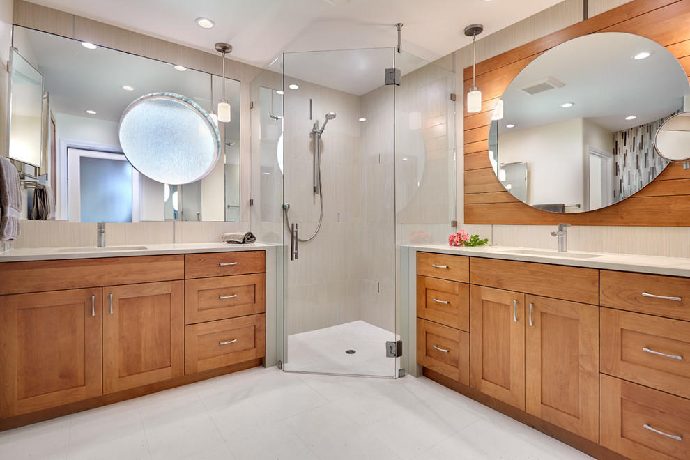Example of a large trendy master multicolored tile and glass tile corner shower design in Sacramento with an undermount sink, recessed-panel cabinets, medium tone wood cabinets, quartz countertops and beige walls
