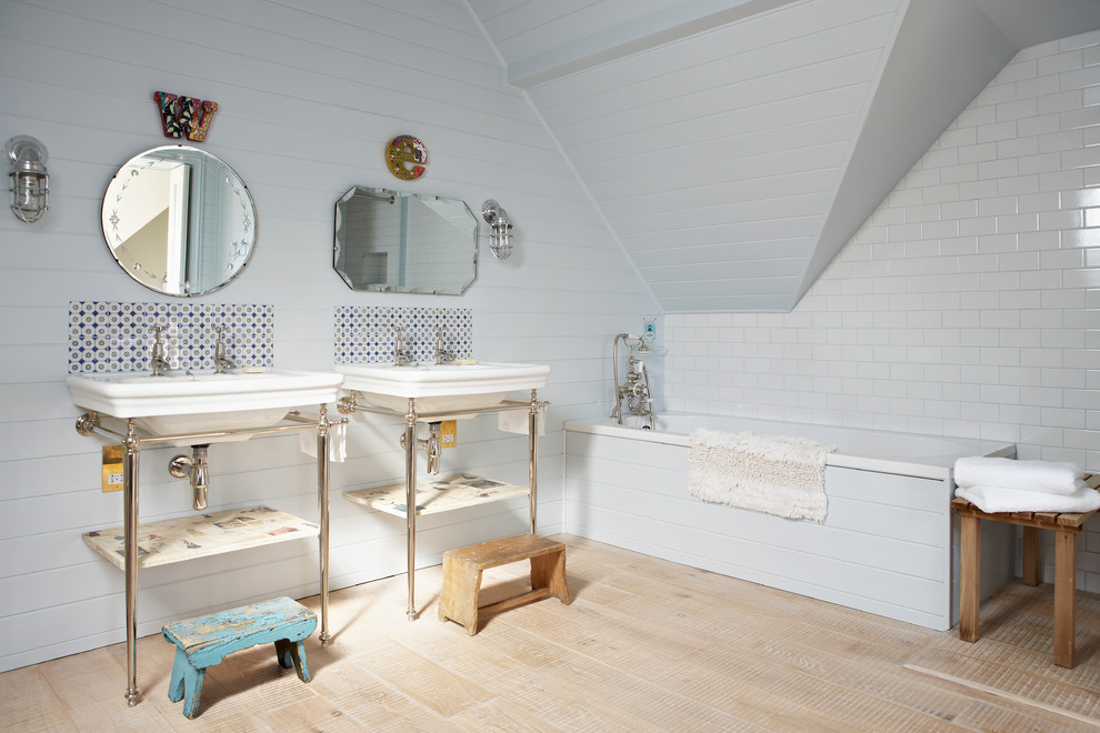 Idée de décoration pour une salle de bain design avec un plan vasque, une baignoire posée, un combiné douche/baignoire, un carrelage multicolore, un mur blanc et parquet clair.