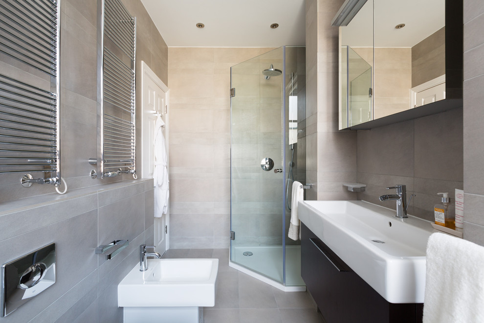 Inspiration for a mid-sized contemporary beige tile corner shower remodel in London with a trough sink, flat-panel cabinets, dark wood cabinets and a bidet