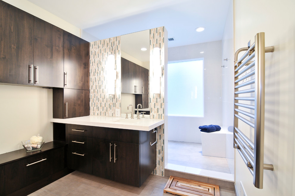 Réalisation d'une grande salle de bain principale design en bois foncé avec un placard à porte plane, un espace douche bain, un mur blanc, un lavabo encastré et un plan de toilette en quartz.
