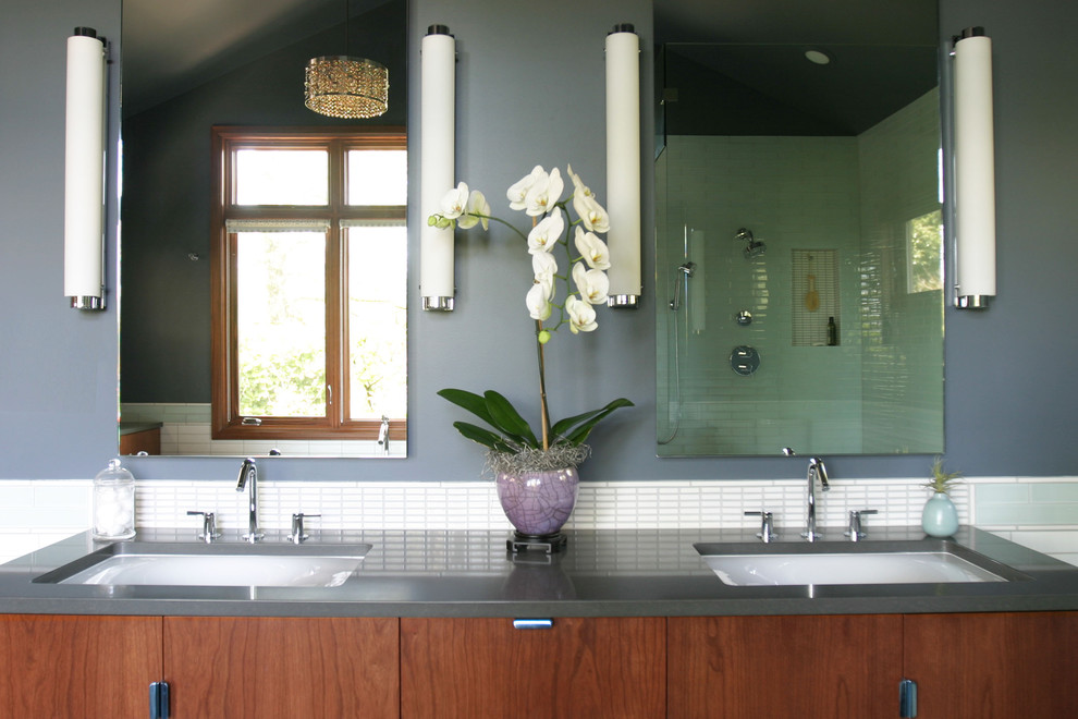 Esempio di una stanza da bagno design con lavabo sottopiano, ante lisce, ante in legno bruno e piastrelle bianche