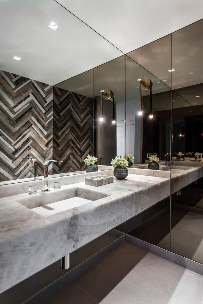 Immagine di una stanza da bagno contemporanea con lavabo integrato, pavimento grigio e top grigio