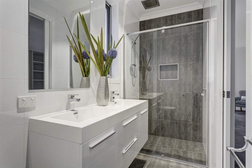 Modernes Duschbad mit flächenbündigen Schrankfronten, weißen Schränken, Duschnische, grauen Fliesen, weißen Fliesen, weißer Wandfarbe, integriertem Waschbecken und Schiebetür-Duschabtrennung in Melbourne