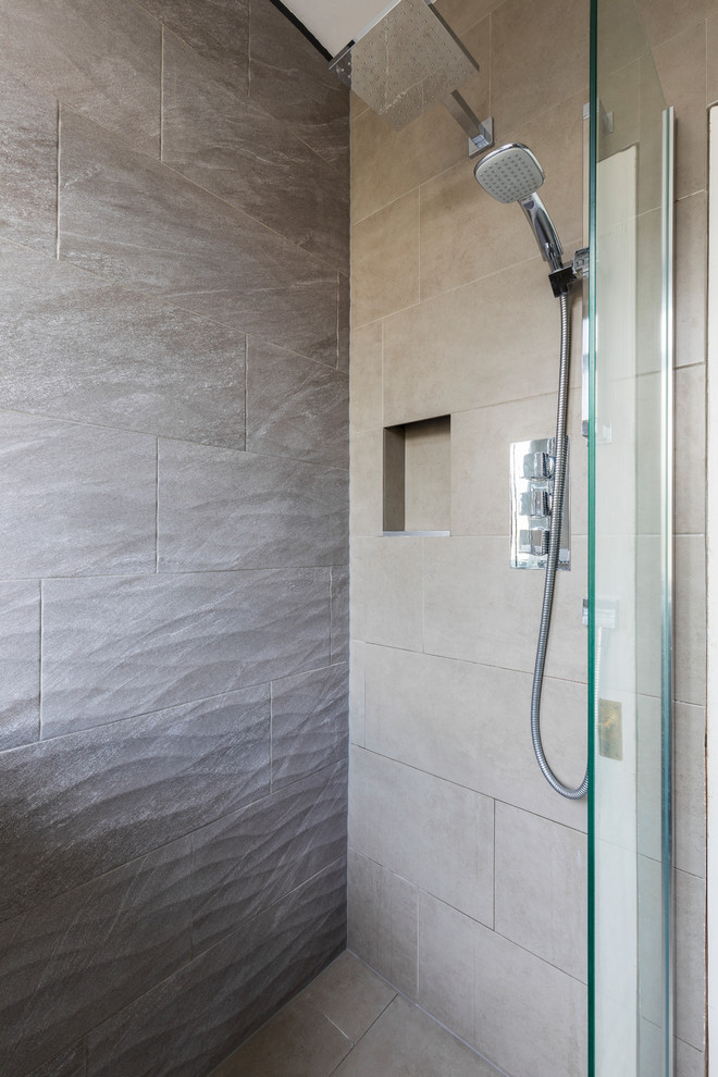 Photo of a small contemporary shower room bathroom in London with open cabinets, beige cabinets, a built-in shower, a one-piece toilet, beige tiles, stone tiles, beige walls, ceramic flooring, a wall-mounted sink and tiled worktops.