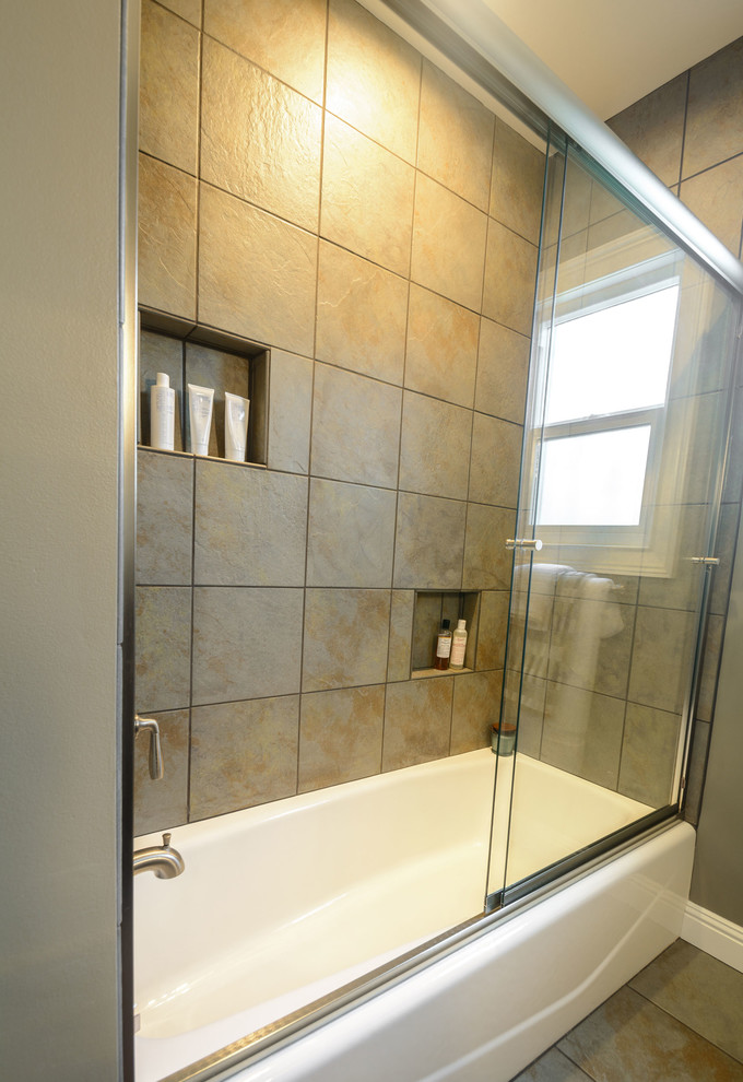 Photo of a medium sized contemporary bathroom in Los Angeles with shaker cabinets, brown cabinets, an alcove bath, a shower/bath combination, a two-piece toilet, beige tiles, porcelain tiles, grey walls, porcelain flooring, a submerged sink and granite worktops.
