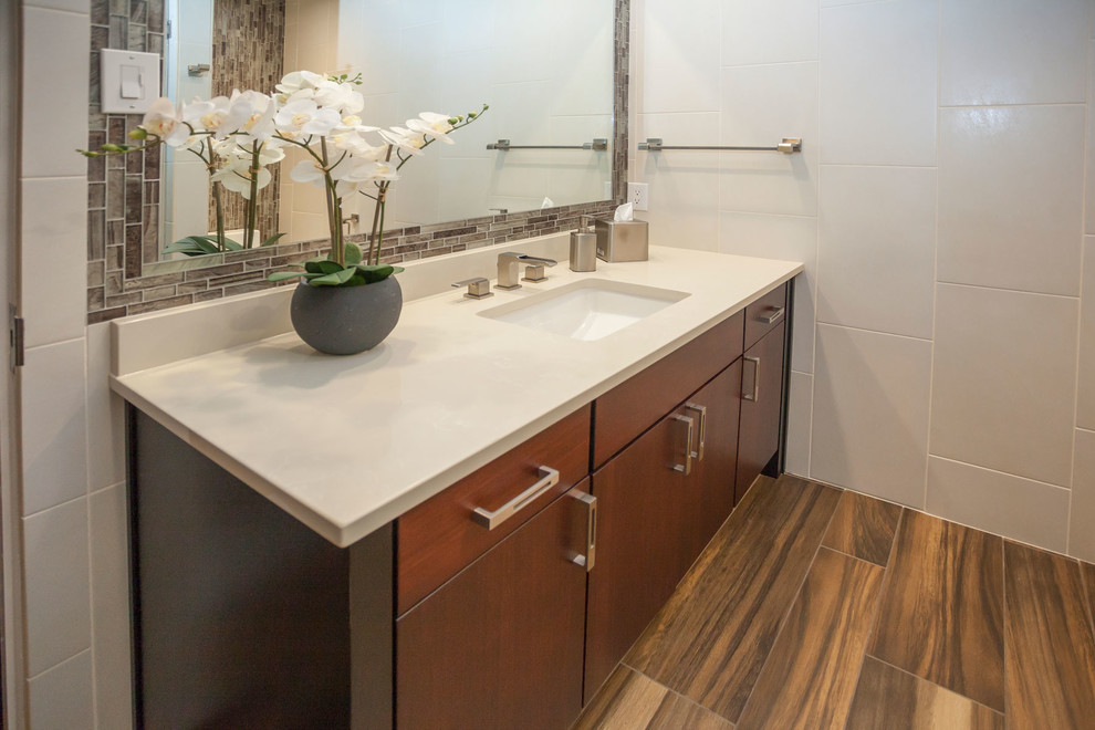 Foto de cuarto de baño contemporáneo con puertas de armario de madera en tonos medios, suelo de madera en tonos medios y lavabo bajoencimera
