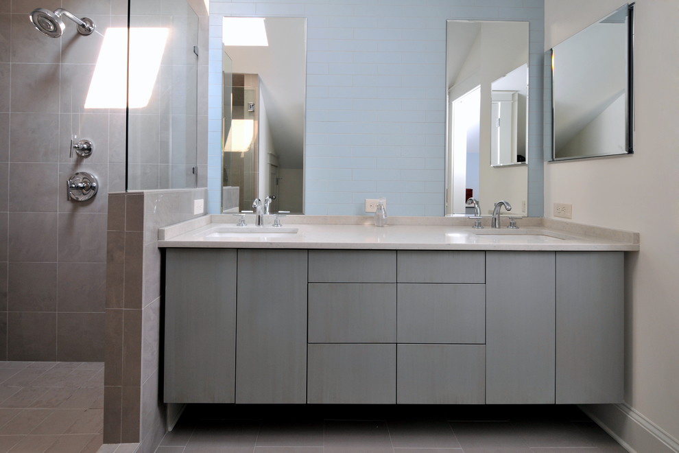 Immagine di una stanza da bagno contemporanea con lavabo sottopiano, ante lisce, ante grigie, doccia aperta, piastrelle blu e doccia aperta