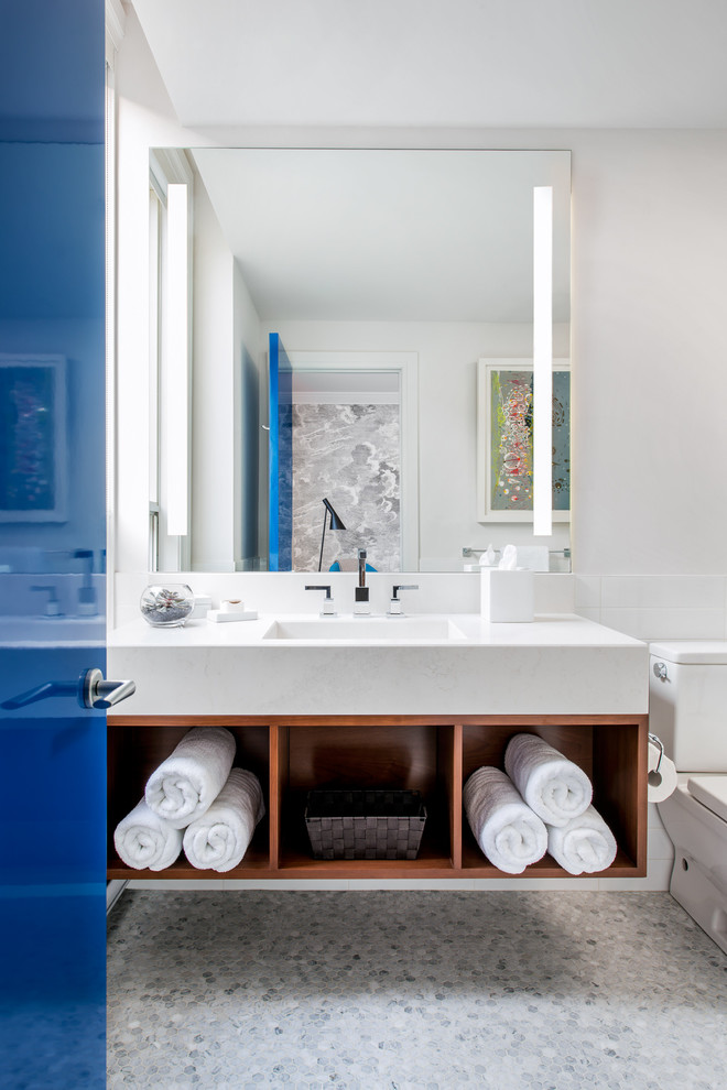 Foto de cuarto de baño principal, actual, de tamaño medio, con lavabo integrado, armarios abiertos, puertas de armario de madera oscura, sanitario de dos piezas, baldosas y/o azulejos blancos, paredes blancas, suelo con mosaicos de baldosas, baldosas y/o azulejos de cerámica y encimera de cuarzo compacto