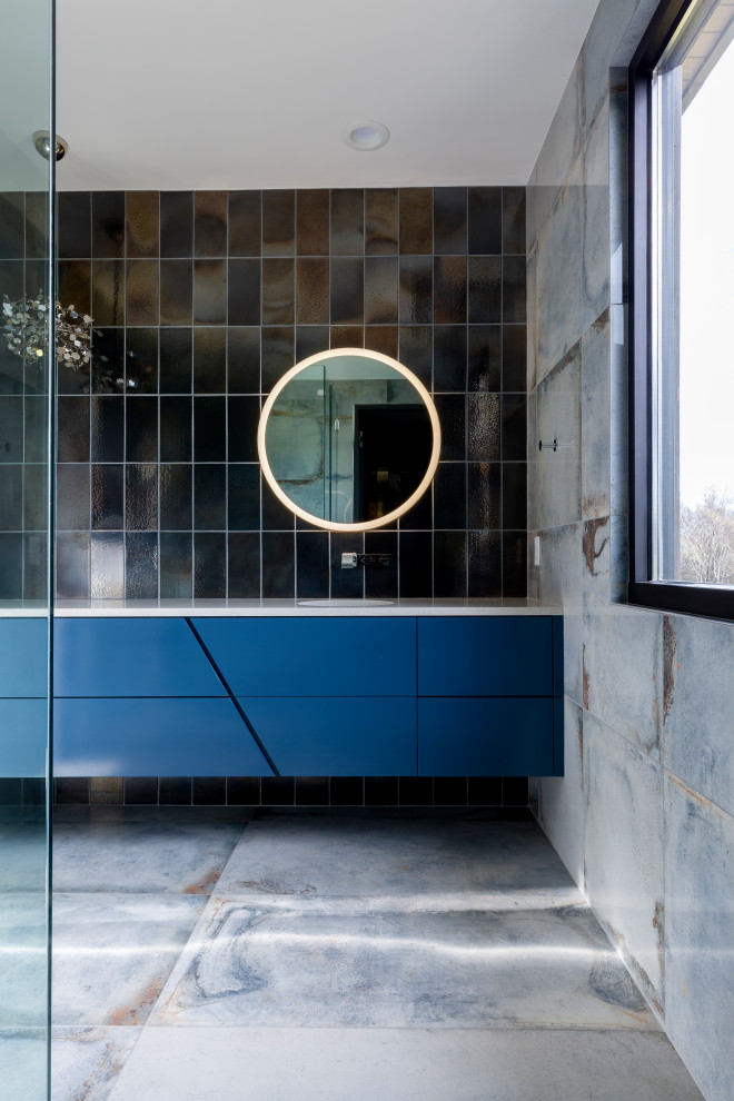 Esempio di una stanza da bagno contemporanea con ante lisce, ante blu, piastrelle nere, lavabo sottopiano, pavimento grigio, top bianco e mobile bagno sospeso