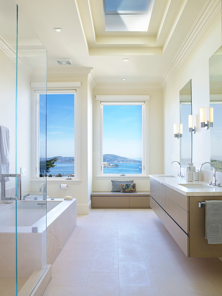 Contemporary ensuite bathroom in San Francisco with a submerged sink, flat-panel cabinets, light wood cabinets, a submerged bath and beige walls.