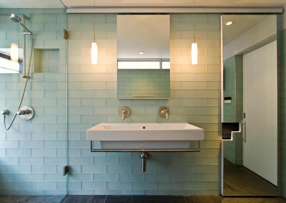 Example of a trendy green tile and glass tile alcove shower design in New York with a wall-mount sink