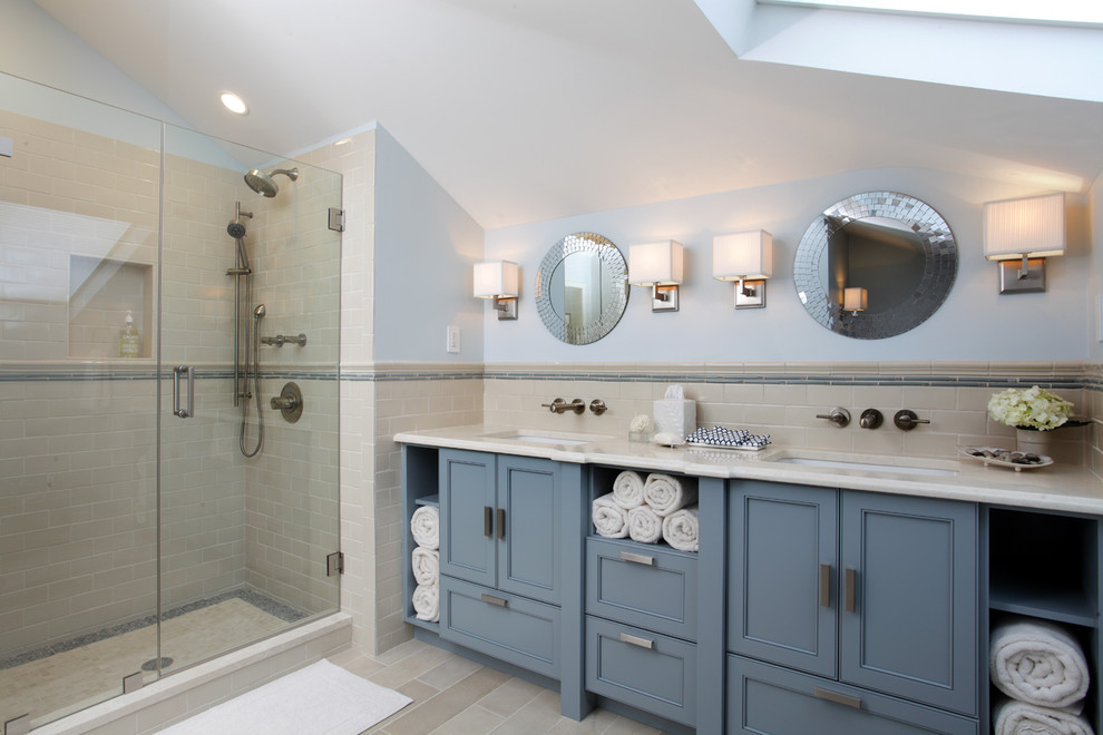 Modern inredning av ett badrum, med ett undermonterad handfat, luckor med infälld panel, blå skåp, en dusch i en alkov, beige kakel och tunnelbanekakel