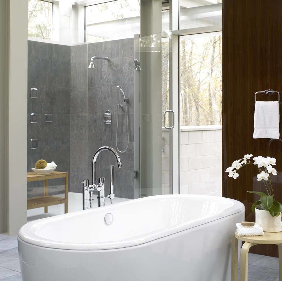 Immagine di una stanza da bagno design con vasca freestanding, doccia a filo pavimento, piastrelle grigie e piastrelle in pietra