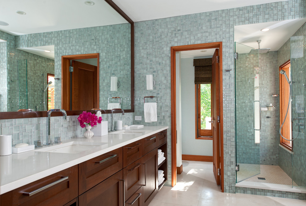 Idee per una stanza da bagno design con lavabo sottopiano, ante in stile shaker, ante in legno bruno, doccia ad angolo, piastrelle blu, piastrelle di vetro e top bianco
