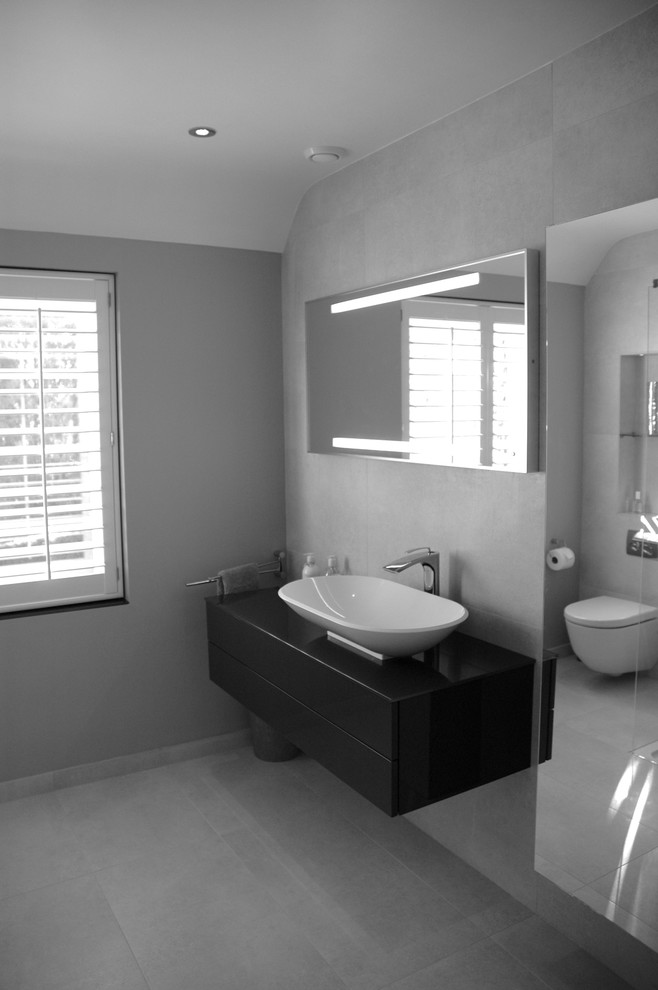 Пример оригинального дизайна: главная ванная комната среднего размера в современном стиле с серыми фасадами, стеклянной столешницей, открытым душем, инсталляцией, бежевой плиткой, керамогранитной плиткой, бежевыми стенами и полом из керамогранита