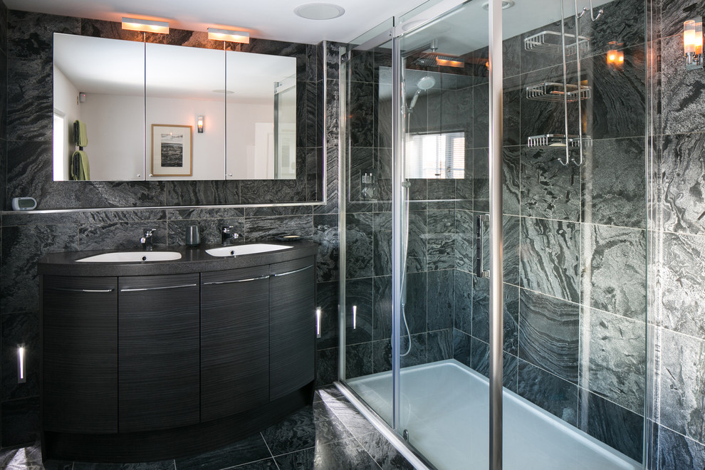 Photo of a small contemporary ensuite bathroom in Other with dark wood cabinets, a double shower, a one-piece toilet and grey tiles.