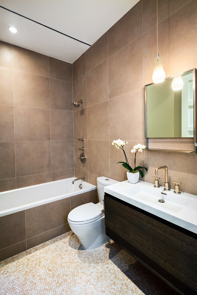 Cette image montre une salle de bain design en bois foncé avec un lavabo intégré, une baignoire en alcôve, un placard à porte plane, un combiné douche/baignoire, WC séparés, un carrelage beige et mosaïque.