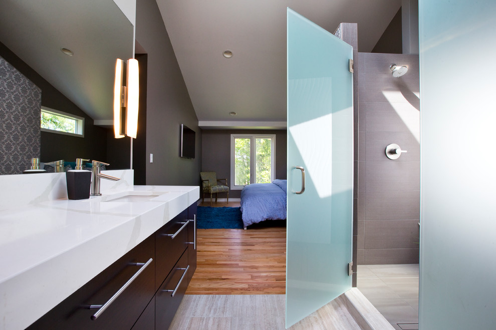 Exemple d'une grande salle de bain principale tendance avec un lavabo intégré, des portes de placard noires, une douche ouverte et un mur gris.
