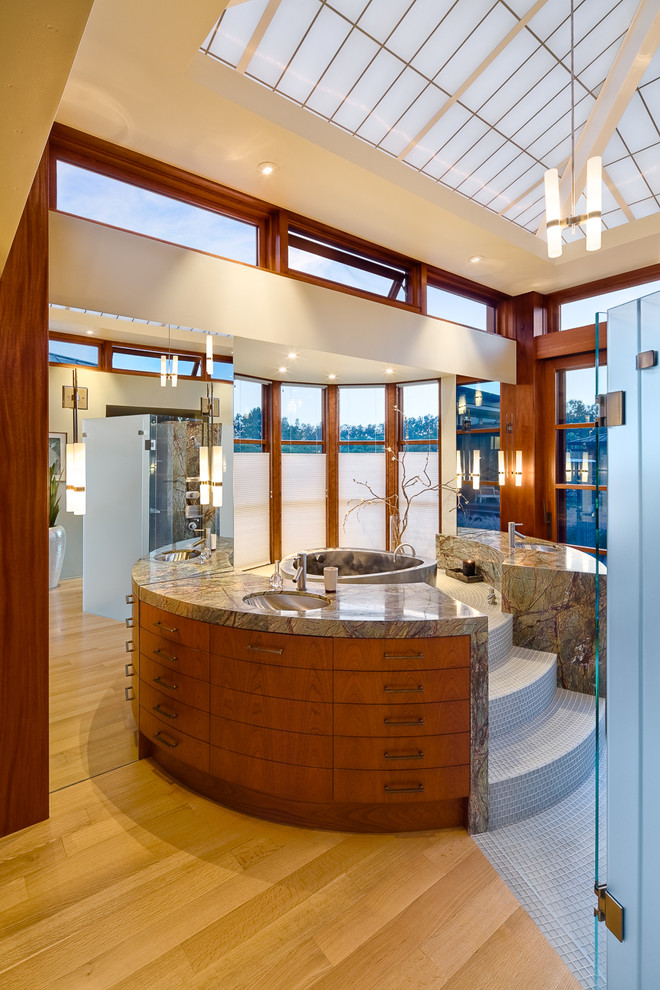 Ejemplo de cuarto de baño contemporáneo con lavabo bajoencimera, armarios con paneles lisos, puertas de armario de madera oscura y baldosas y/o azulejos grises
