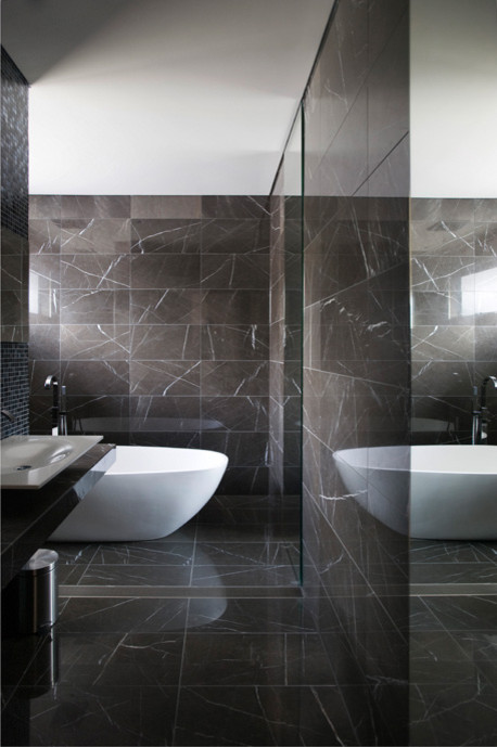Modelo de cuarto de baño actual con baldosas y/o azulejos grises, baldosas y/o azulejos de piedra, lavabo sobreencimera, bañera exenta y ducha abierta