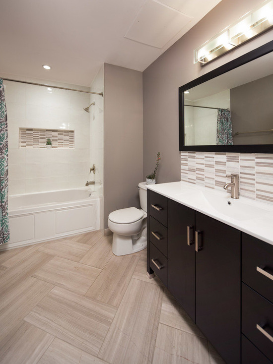 Photo of a medium sized contemporary ensuite bathroom in Chicago with flat-panel cabinets, dark wood cabinets, an alcove bath, a shower/bath combination, a two-piece toilet, multi-coloured tiles, mosaic tiles, grey walls, limestone flooring, an integrated sink and marble worktops.