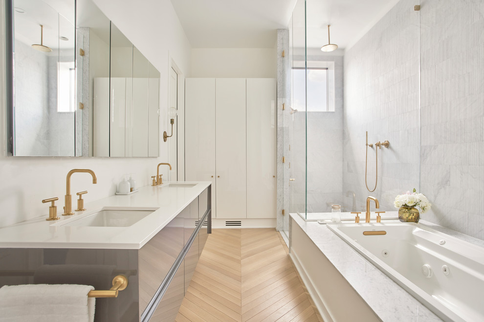 На фото: главная ванная комната в современном стиле с плоскими фасадами, серыми фасадами, накладной ванной, угловым душем, белой плиткой, белыми стенами, светлым паркетным полом, врезной раковиной, бежевым полом и душем с распашными дверями с