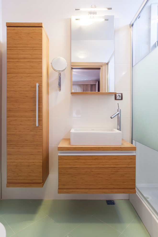 Cette photo montre une salle de bain tendance en bois clair avec une vasque, un placard à porte plane et un plan de toilette en bois.