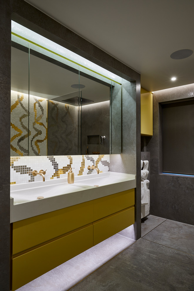 Источник вдохновения для домашнего уюта: ванная комната в современном стиле с плоскими фасадами, желтыми фасадами, разноцветной плиткой, серыми стенами, монолитной раковиной и серым полом