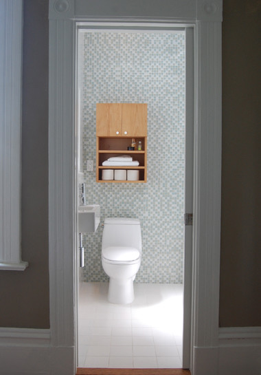 Ispirazione per una piccola stanza da bagno minimal con lavabo sospeso, ante lisce, ante in legno chiaro, vasca ad alcova, doccia alcova, piastrelle blu, piastrelle a mosaico e pavimento con piastrelle in ceramica