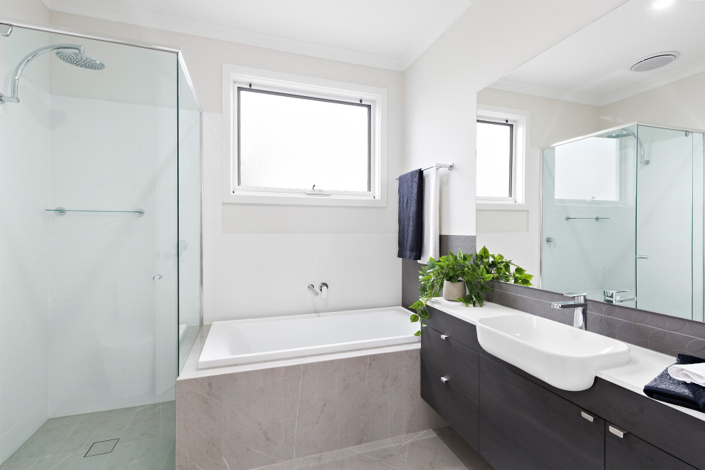 Modernes Badezimmer En Suite mit flächenbündigen Schrankfronten, schwarzen Schränken, Einbaubadewanne, grauen Fliesen, grauer Wandfarbe, Aufsatzwaschbecken, grauem Boden und weißer Waschtischplatte in Adelaide