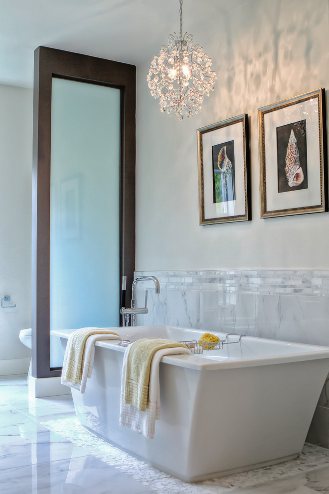 Exempel på ett modernt badrum, med ett fristående badkar, grå kakel och porslinskakel