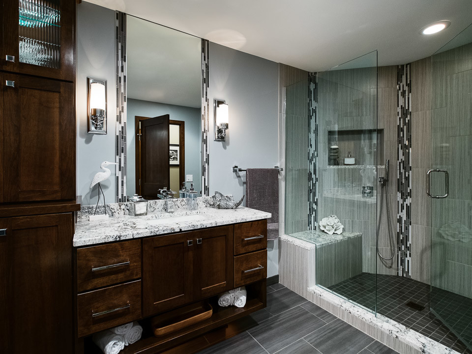 Medium sized contemporary ensuite bathroom in Minneapolis with a submerged sink, open cabinets, dark wood cabinets, granite worktops, a walk-in shower, a one-piece toilet, grey tiles, grey walls and porcelain flooring.