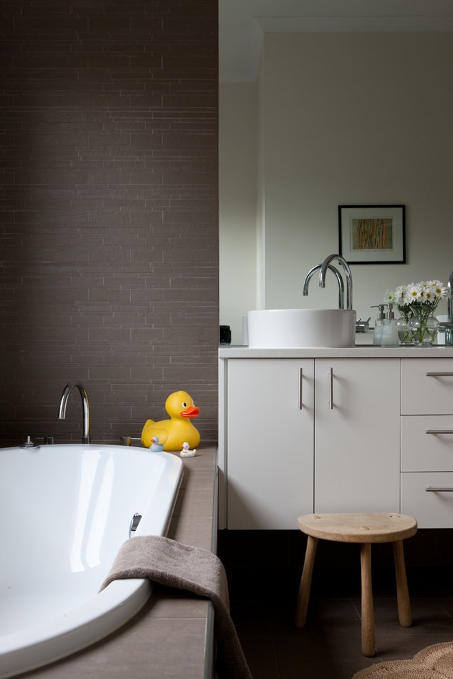 Example of a trendy gray tile drop-in bathtub design in Adelaide with a vessel sink, flat-panel cabinets and gray cabinets