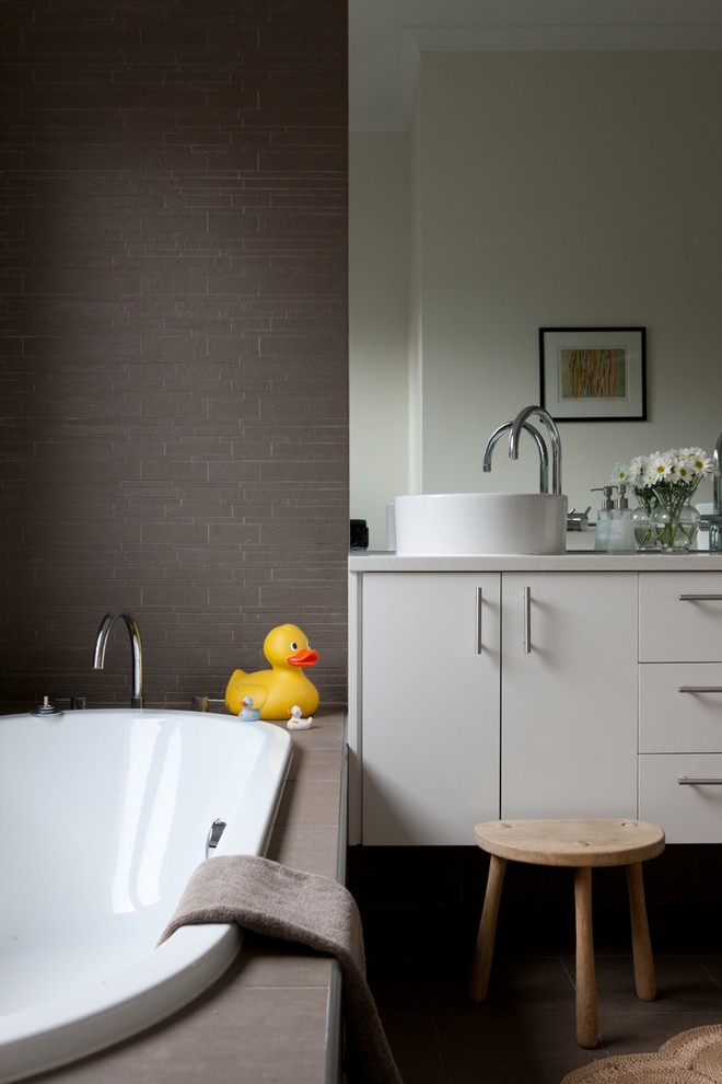 Inspiration för ett funkis badrum, med ett fristående handfat, släta luckor, grå skåp, ett platsbyggt badkar och grå kakel