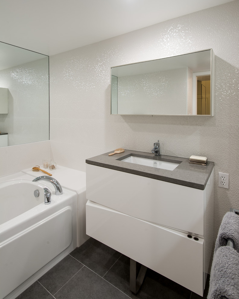 Aménagement d'une salle de bain contemporaine avec un lavabo encastré, un placard à porte plane, des portes de placard blanches, un carrelage gris et un plan de toilette gris.