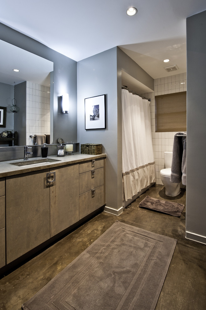 Свежая идея для дизайна: ванная комната: освещение в современном стиле с плоскими фасадами, ванной в нише, душем над ванной и бетонным полом - отличное фото интерьера