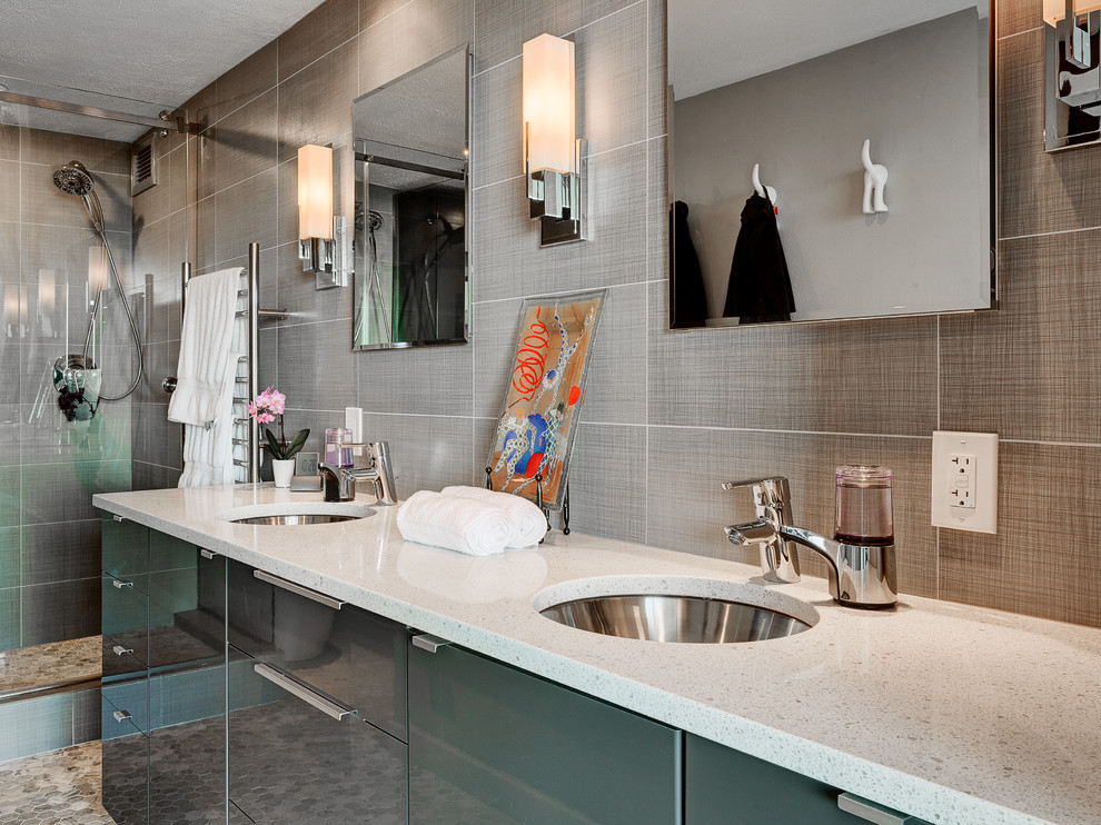 Foto di una stanza da bagno contemporanea con lavabo sottopiano, ante lisce, ante grigie, top in granito, doccia alcova, WC sospeso, piastrelle beige e piastrelle in ceramica