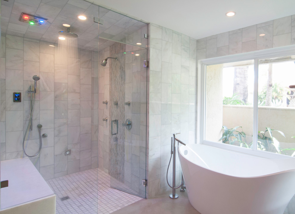На фото: большая главная ванная комната в современном стиле с отдельно стоящей ванной, двойным душем, белой плиткой, мраморной плиткой, белыми стенами, мраморным полом, бежевым полом и душем с распашными дверями с